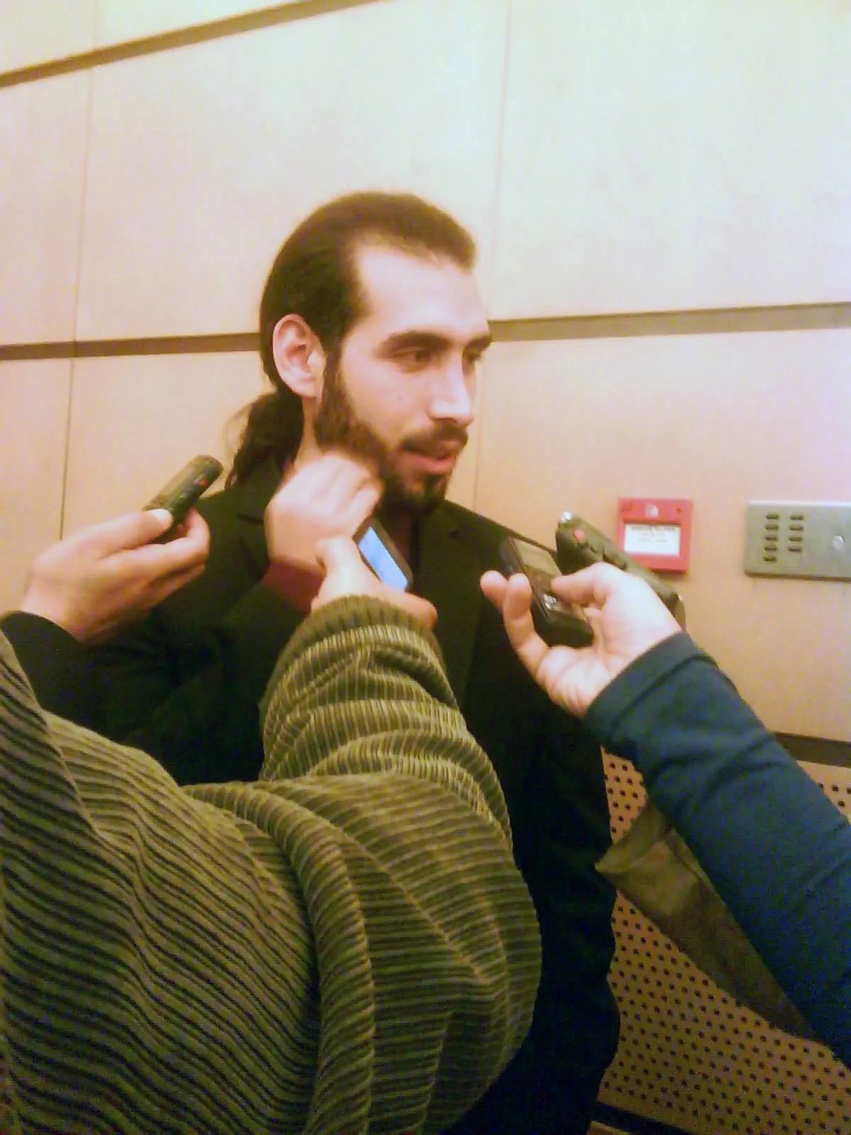 Molham Mahmoud mid-answer, surrounded by recorders at the ceremony